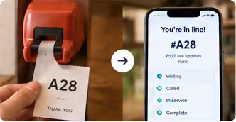 A paper number ticket next to a phone showing the customer’s place in line